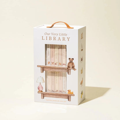 Box packaging for 'Our Very Little Library' with illustrations of a shelf and teddy bear on a beige background.