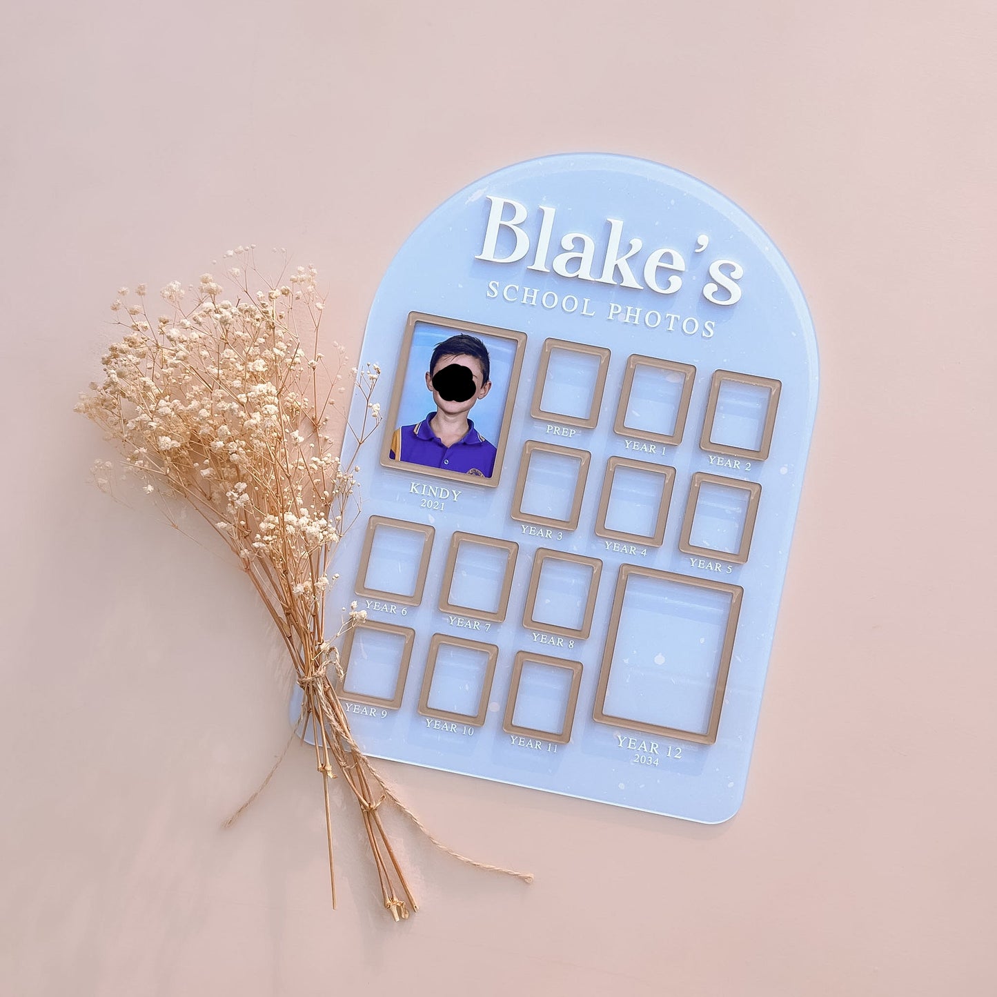 Blue photo board with 'Blake's School Photos' on a beige background