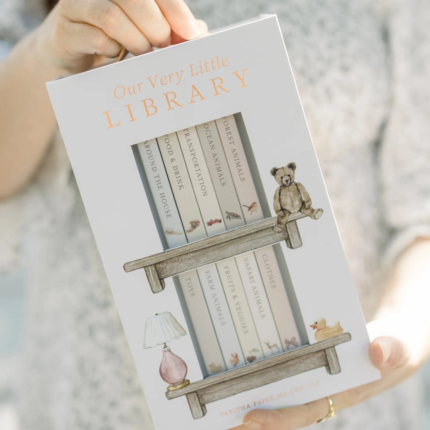 Book titled 'Our Very Little Library' held by a person
